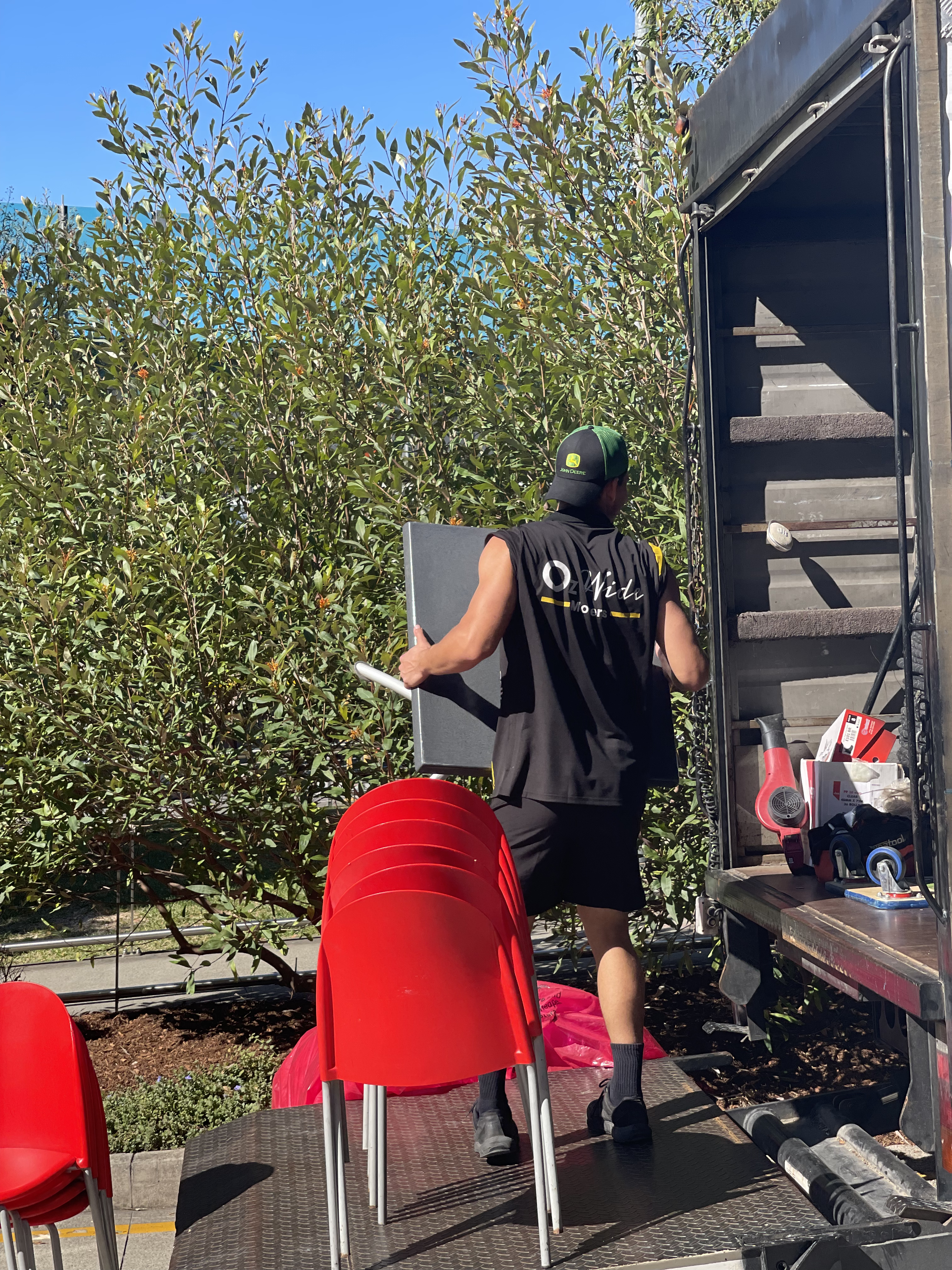 Two movers standing in the back of an open removals truck