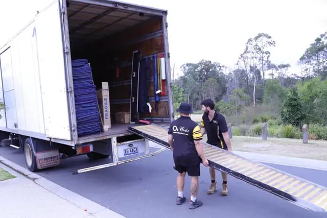 Removalists standing in front of trucks